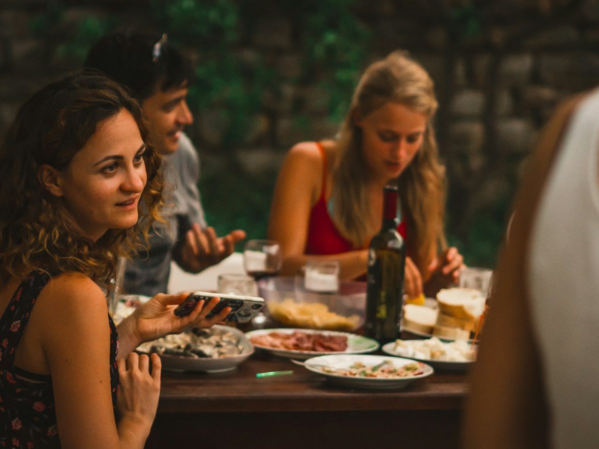 Familiares y amigos compartiendo la cena en una mesa larga