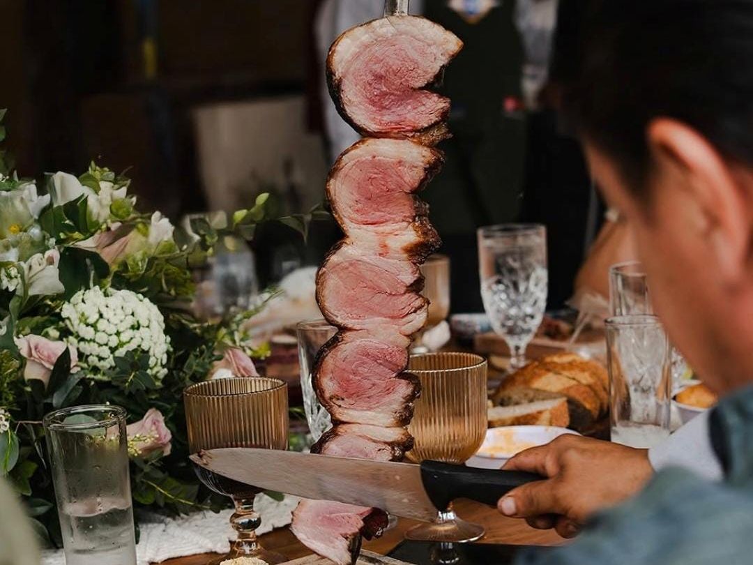 Espada brasileña con cortes de picaña rebanados en la mesa