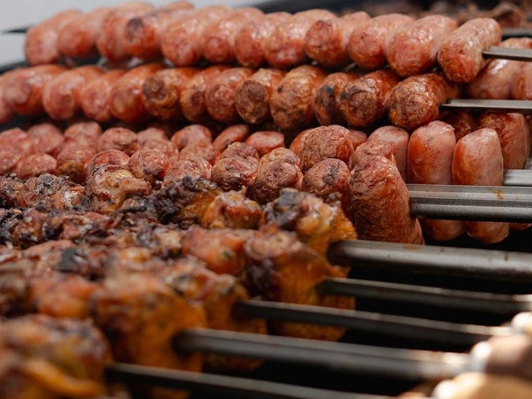Espadas de chorizo y pollo dorándose en la parrilla